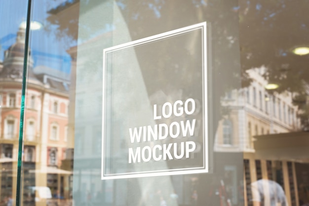 Logo, sign mockup on store glass window. City buildings in background