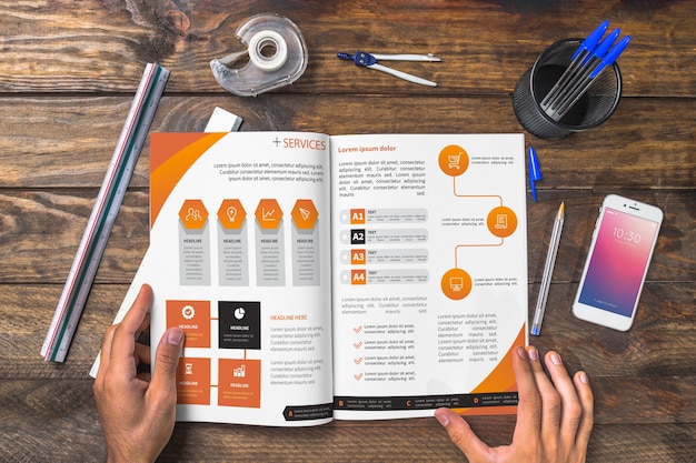 Magazine and smartphone mockup on wooden table with pens and rulers