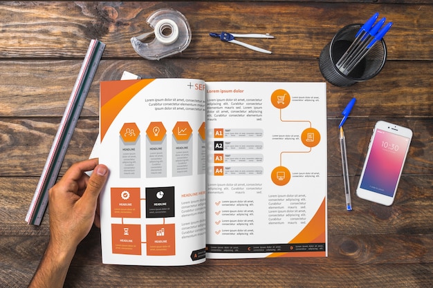 Magazine and smartphone mockup on wooden table with pens and rulers 