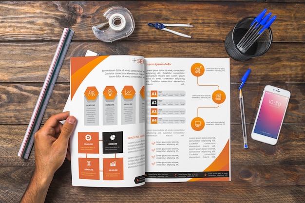 Magazine and smartphone mockup on wooden table with pens and rulers