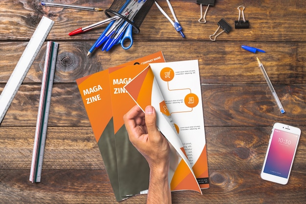 Magazine and smartphone mockup on wooden table with pens and rulers