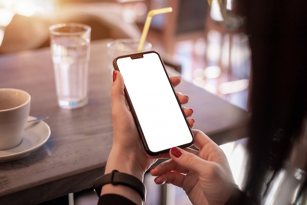 Makieta inteligentny telefon w ręce kobiety. Koncepcja wykorzystania aplikacji na telefon i inteligentnej bransoletki