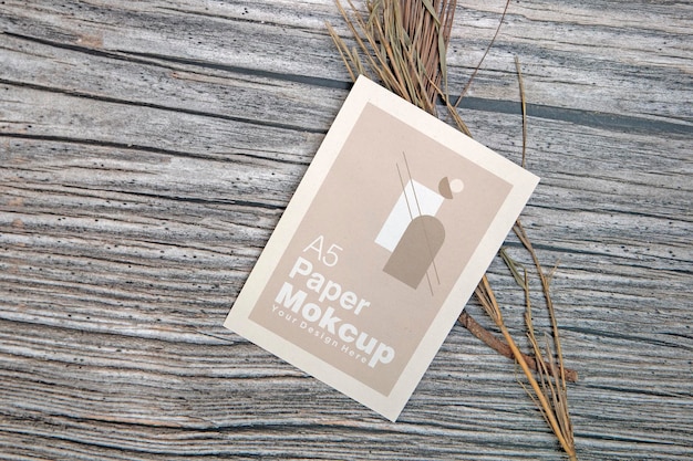PSD makieta kartki z życzeniami papieru a5 z suchymi liśćmi na drewnianym tle