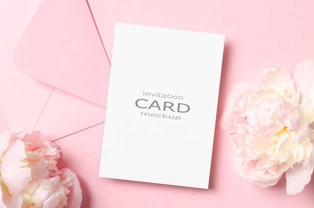 Makieta karty zaproszenia ślubne z kopertą i różowymi kwiatami piwonii