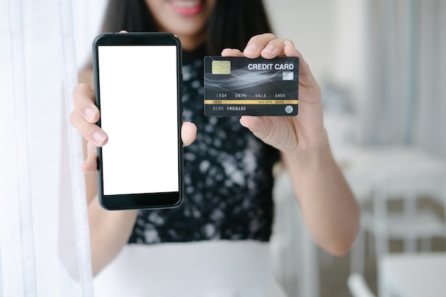 Makieta piękna kobieta trzyma karty kredytowej zakupy online ze smartfonem na stronach internetowych