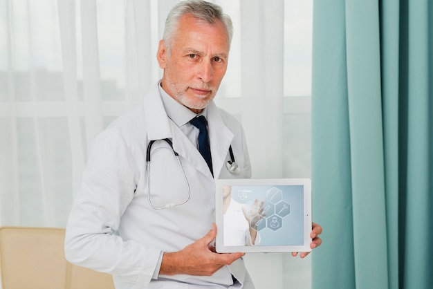 Male doctor holding a tablet