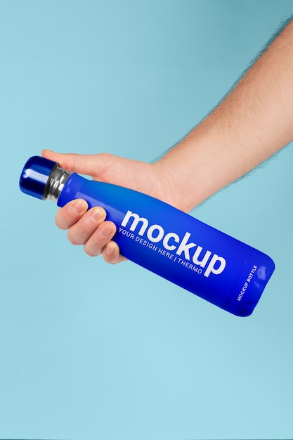 Male hand holding mock-up of blue thermos bottle