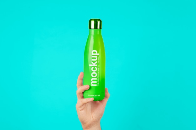 Male hand holding mock-up of green thermos bottle