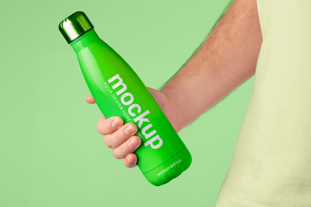 Mano maschio che tiene il modello della bottiglia di thermos verde