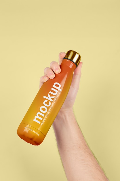 PSD male hand holding mock-up of orange thermos bottle