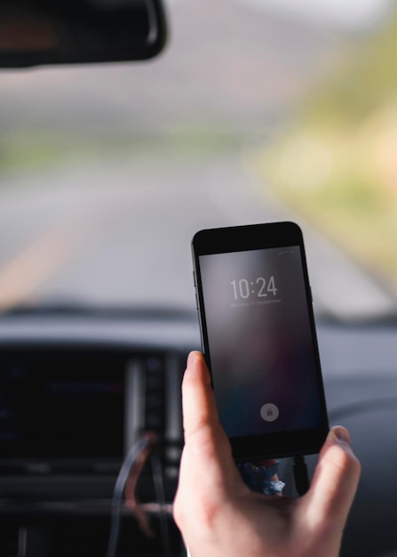 Man controleert een tijd vanaf zijn telefoon in een auto