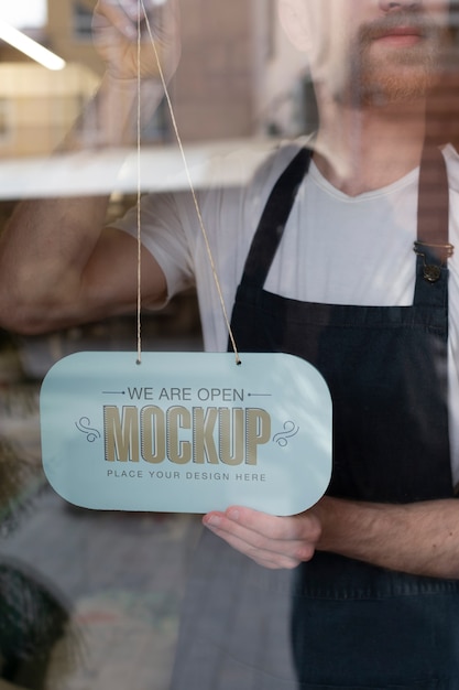 Man hanging we are open sign mock-up in business window