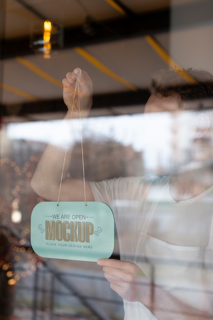 Man hanging we are open sign mock-up in business window