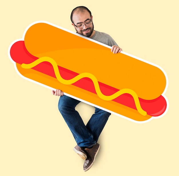 Uomo che tiene un grosso hot dog