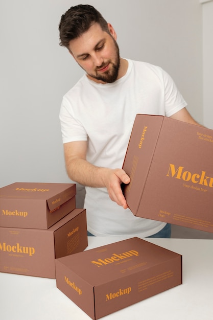 PSD man holding boxes mockup design