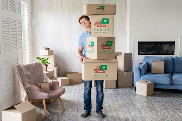 PSD man holding boxes with objects in his new house long view