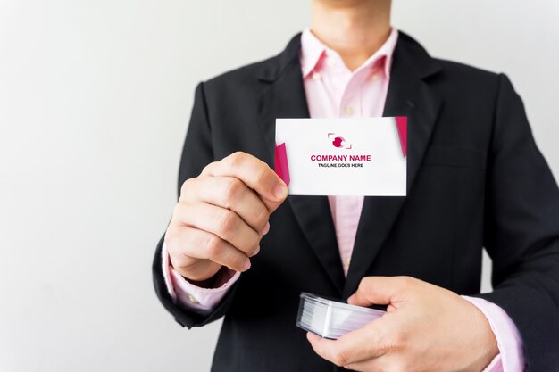 PSD man holding a business card mockup