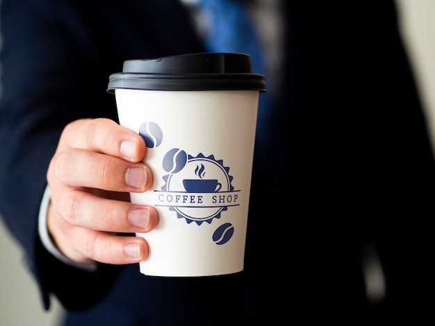 Uomo che tiene un modello di tazza di caffè