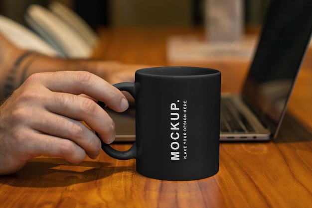 PSD a man holding a coffee mug that says mockup on it.