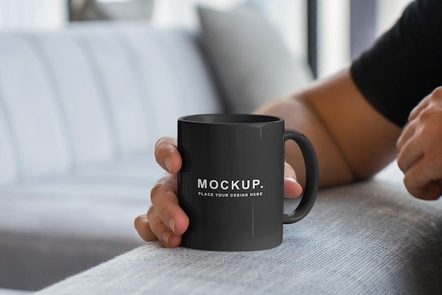 A man holding a coffee mug with mockup