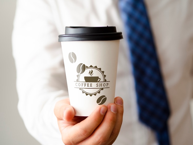 PSD uomo che tiene un modello della tazza di caffè