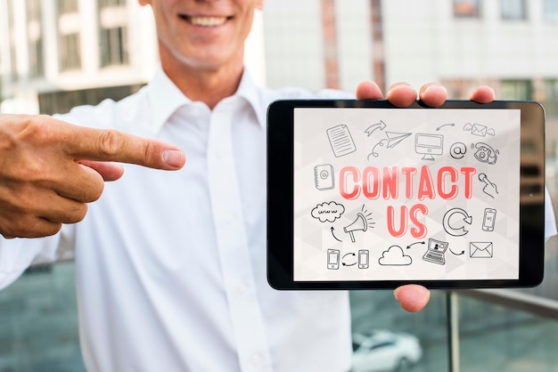 man holding digital tablet and pointing at it