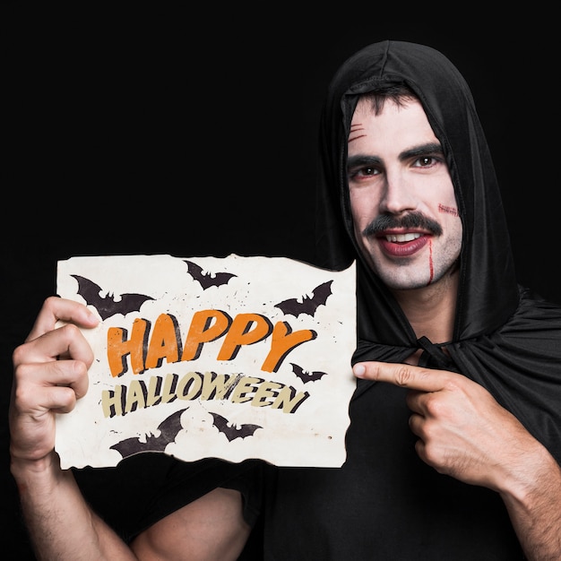 PSD uomo che tiene la carta con lettering di halloween