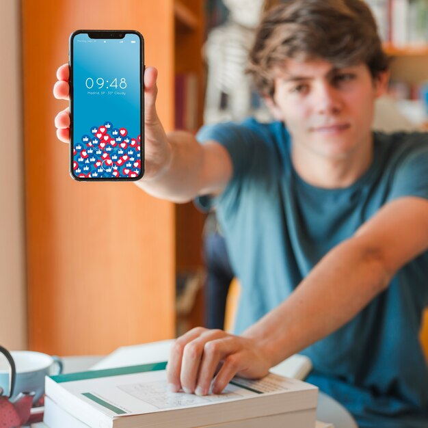 Man holding smartphone mockup in library