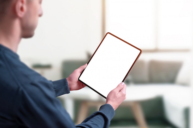 PSD man holding tablet with isolated screen for mockup.