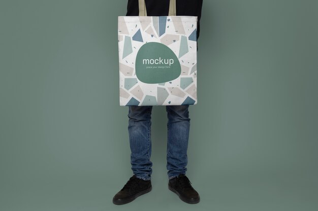 Man holding tote bag with green background