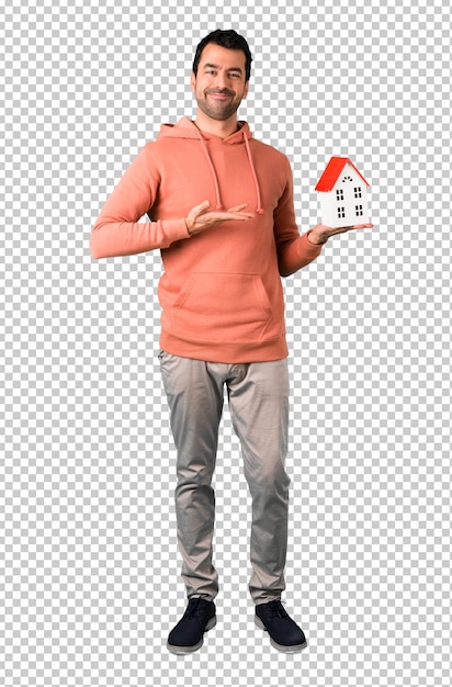 Man in een roze sweatshirt met een klein huis