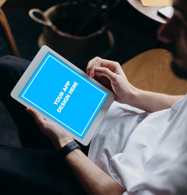 A man is holding a tablet with the words your app on it