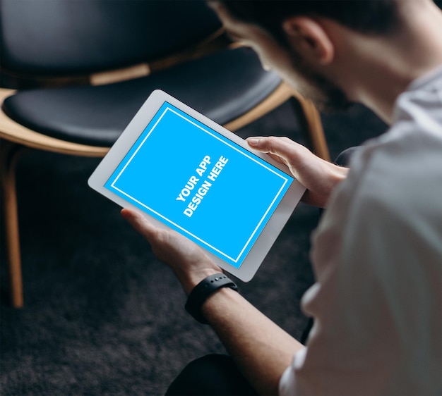 A man is looking at a tablet with the word forum on it.