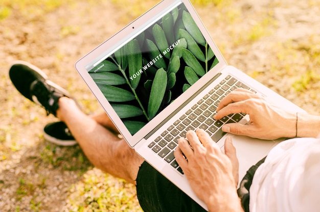 Man met laptop mockup in de natuur