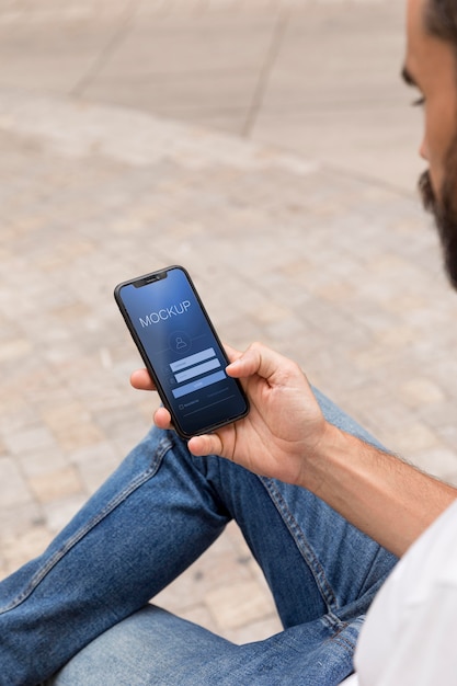 Man op straat met telefoon met app