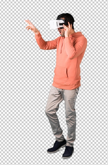 Man in a pink sweatshirt using VR glasses. Virtual reality experience