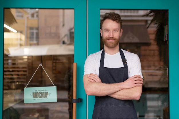 Man posing with we are open sign mock-up in business window