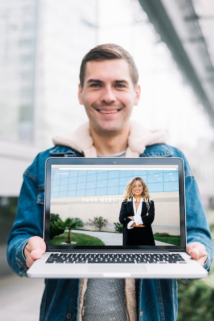 PSD man presenting laptop mockup