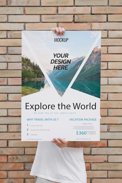 Man presenting poster mockup in front of brick wall