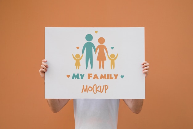 Man presenting poster mockup on orange background