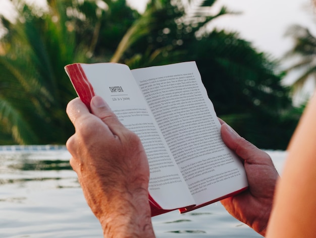 Uomo che legge un libro in piscina