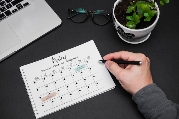 Man's hand writing on calendar