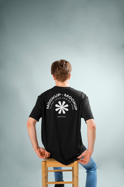 PSD man showing back of t-shirt mock-up