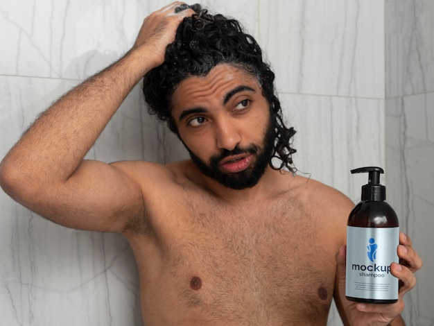 Uomo che mostra il design del modello di bottiglia di shampoo