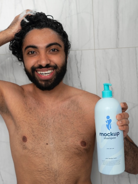 Uomo che mostra il design del modello di bottiglia di shampoo