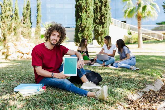 Man showing tablet mockup in park