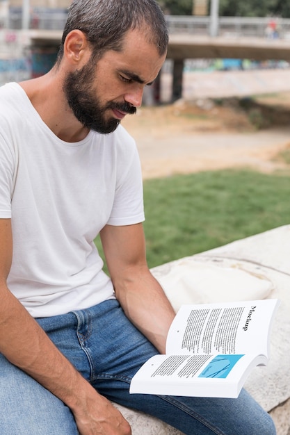 Man on street reading book