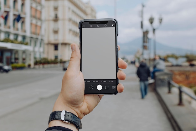 スマートフォンで街の写真を撮る男