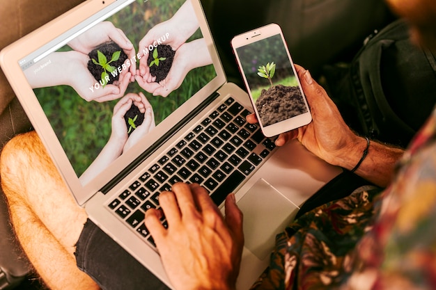 PSD uomo che usando il modello di smartphone e laptop con il concetto di natura