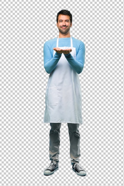 PSD man wearing an apron holding copyspace imaginary on the palm to insert an ad